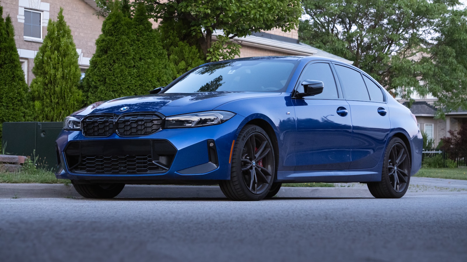 A blue BMW sedan parked on a suburban street.